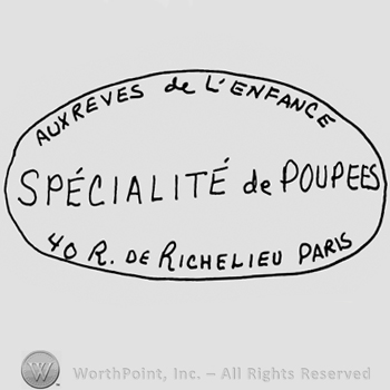 Aux reves de L'Enfance Specialite de Poupees, 40 R. de Richelieu Paris written with uppercase letters inside an oval design