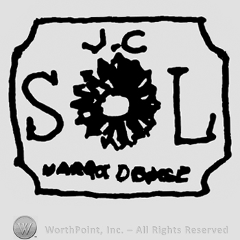Uppercase J.C. SL with flower in the center, undescifrable writing below, all on a rectangular design
