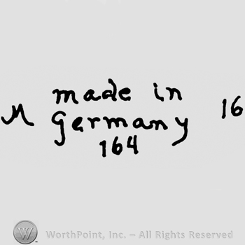 Made in Germany written with lowercase letters over number 164 precedeed by uppercase handwritten M and followed by number 16