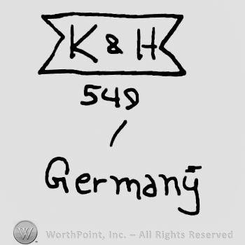 Uppercase K&H on a ribbon over number 549 and Germany written with lowercase letters