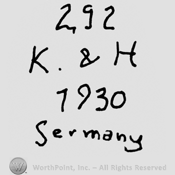 Number 292 over uppercase K&H, number 1930 over Germany written with lowercase letters