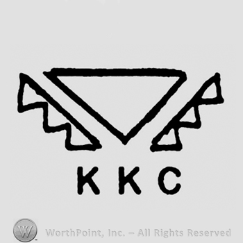 Triangle between two serrated symbols, letters KKC written below in uppercase.