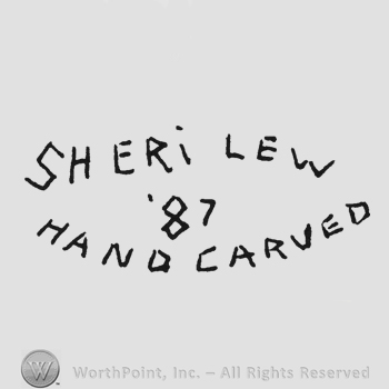 Curved writing Sheri Lew up Handcarved under 87 middle all capital letetrs