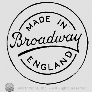 Writings on circular panel: capital writings above: Made in, below: England, Broadway handwritten and underline din the center