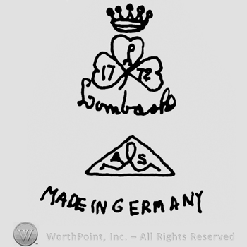 Crown over a three-leaf clover, uppercase handwritten L and numbers 17 and 72 written on it's leaves, Lumbach handwritten below, Triangle with letters and line inside over Made In Germany written with uppercase letters