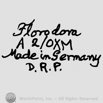 Florodora handwritten with lowercase letters over uppercase A, number 2/0X, uppercase M, Made in Germany written below with lowercase letters over uppercase D.R.P.