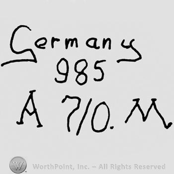 Germany written with lowercase letters over number 985, uppercase Am, number 7/0 and uppercase M written below
