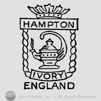 Tea pot inside stylish frame. Hampton written on the upper border, Ivory written on the bottom border. Crown on top. England on the bottom