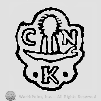 Letters C tree N above K between two white pearls