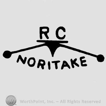Uppercase letters RC written over two leaned sticks and Noritake written below in uppercase letters.