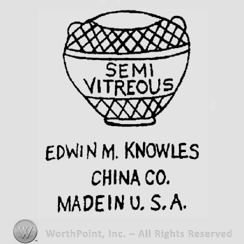 A vase with stripes, Semi Vitreous written on it, the text Edwin M. Knowles China Co. Made in U.S.A. written below in uppercase letters.