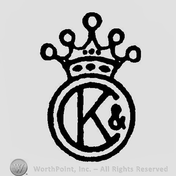 A crown above a circle with the letters K & C overlapping inside