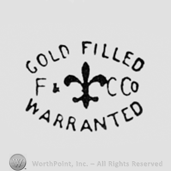 Fleur-de-lis between written words GOLD FILLED WARRANTED and letters F&C CO.