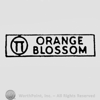 Words ORANGE BLOSSOM and double T inside a circle.