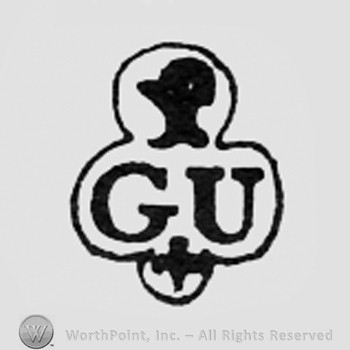 Shape like a head above letters GU; cross bellow.