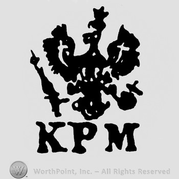 An eagle with crown,cross and scepter;letters KPM below.