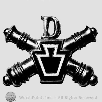 Insignia consisted of crossed cannons and a shield; letter D above.