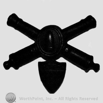 Insignia consisted of crossed cannons and shield with bullet at the intersection; shield below.