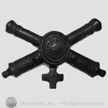 Insignia consisted of crossed cannons and a shield at the intersection; cross below.