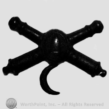 Insignia consisted of crossed cannons and a bullet at the intersection; crescent below.
