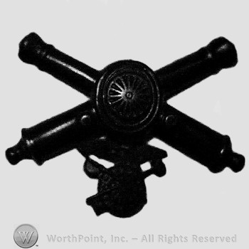 Insignia consisted of crossed cannons and a bullet at the intersection; compass below.