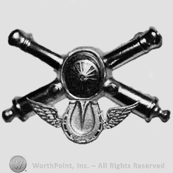 Insignia consisted of crossed cannons and a shield at the intersection; winged horseshoe below.