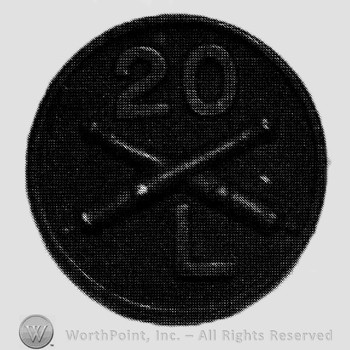 Insignia consisted of crossed cannons  and number 20 above, letter L below; all on a disc.