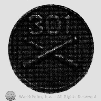 Insignia consisted of crossed cannons and number 301 above, on a disc.