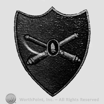 Insignia consisted of crossed cannons with a bullet at the intersection; all on a shield.