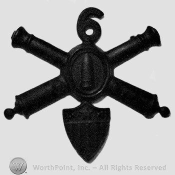 Insignia consisted of crossed cannons with a bullet at the intersection and a shield below; number 6 above.
