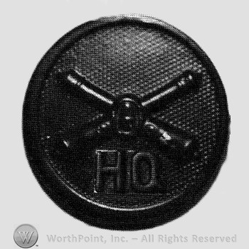 Insignia consisted of crossed cannons and a bullet at the intersection; letters HQ below; all on a disc.