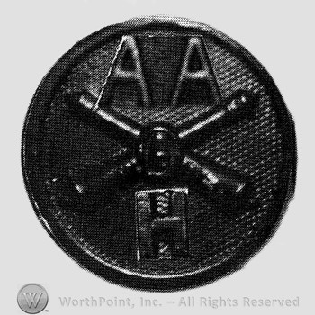 Insignia consisted of crossed cannons and a bullet at the intersection; letters AA above and H below; all on a disc.