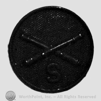 Insignia consisted of crossed cannons and letter S below; all on a disc.