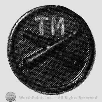 Insignia consisted of crossed cannons and letters TM above, on a disc.