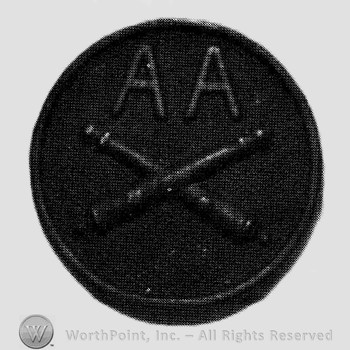 Insignia consisted of crossed cannons and letters AA above, on a disc.