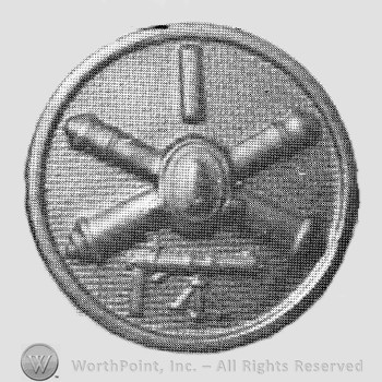 Insignia consisted of crossed cannons with a bullet at the intersection; some arm below; all on a disc.