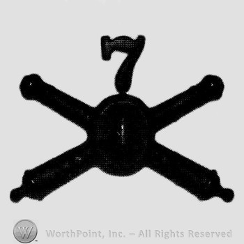 Insignia consisted of crossed cannons with bullet at the intersection and number 7 above.