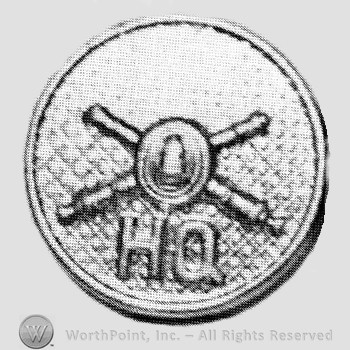 Insignia consisted of crossed cannons with a bullet at the intersection and letters HQ below; all on a plate.