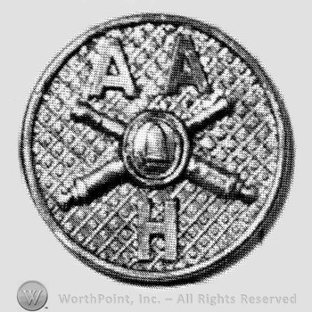 Insignia consisted of crossed cannons with a bullet at the intersection and letter H below, letters AA above; all on a plate.