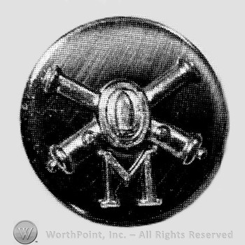 Insignia consisted of crossed cannons with a bullet at the intersection and letter M below; all on a plate.