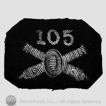 Insignia consisted of crossed cannon with a bullet at the intersection; number 105 above.