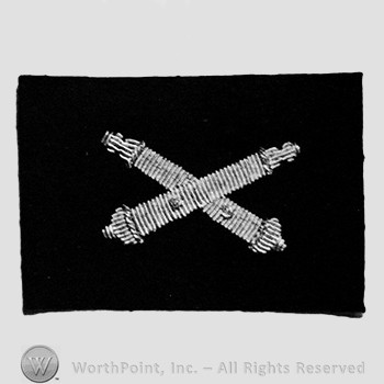 Insignia consisted of crossed cannon.