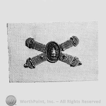 Insignia consisted of crossed cannon and a bullet at the intersection.
