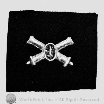 Insignia consisted of embroidered crossed cannon with a bullet at the intersection.