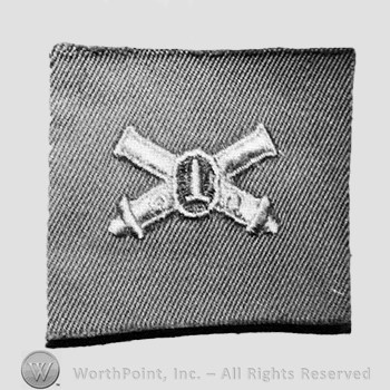 Insignia consisted of embroidered crossed cannon with a bullet at the intersection.