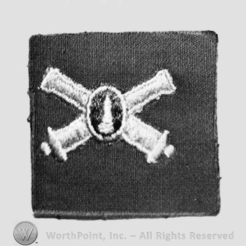 Insignia consisted of embroidered crossed cannon with a bullet at the intersection.