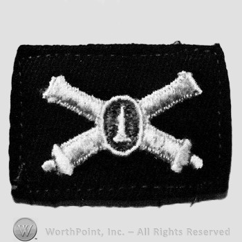Insignia consisted of embroidered crossed cannon with a bullet at the intersection.