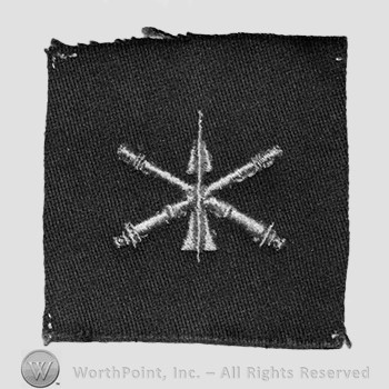 Insignia consisted of embroidered crossed cannon with a missile at the intersection.
