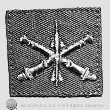 Insignia consisted of embroidered crossed cannon with a missile at the intersection.