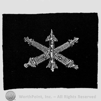 Insignia consisted of embroidered crossed cannon with a missile at the intersection.